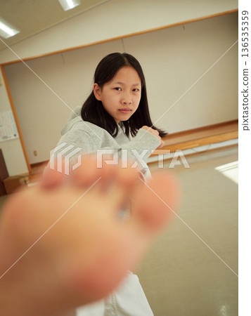 一名國中女生在教室裡練習空手道 一名國中女生在教室裡練習空手道 136535359