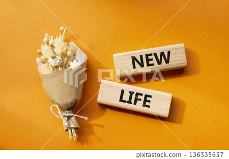 New life symbol. Concept word New life on wooden blocks. Beautiful orange background with bouquet of flowers. Business and New life concept. Copy space 136535657