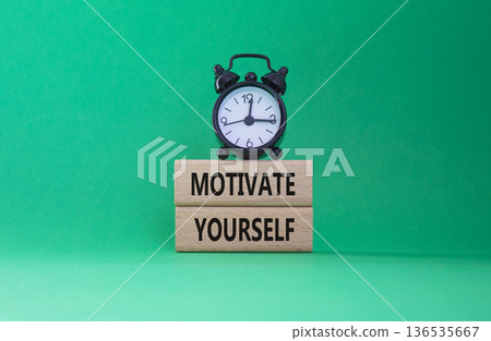Motivation symbol. Concept words Motivate yourself on wooden blocks. Beautiful green background with alarm clock. Business and Motivate yourself concept. Copy space. Motivation symbol. Concept words Motivate yourself on wooden blocks. Beautiful green background with alarm clock. Business and Motivate yourself concept. Copy space. 136535667