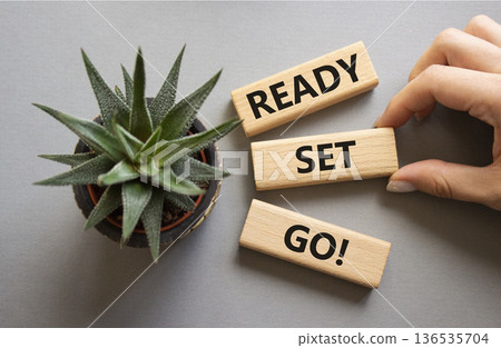 Ready Set Go symbol. Concept words Ready Set Go on wooden blocks. Beautiful grey background with succulent plant. Businessman hand. Business and Ready Set Go concept. Copy space. 136535704