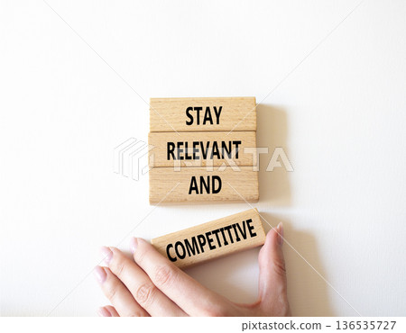 Relevant and Competitive symbol. Concept words Stay Relevant and Competitive on wooden blocks. Beautiful bright white background. Businessman hand. Business and Stay Relevant and Competitive concept. Relevant and Competitive symbol. Concept words Stay Relevant and Competitive on wooden blocks. Beautiful bright white background. Businessman hand. Business and Stay Relevant and Competitive concept. 136535727