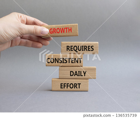 GROWTH symbol. Wooden blocks with words GROWTH REQUIRES CONSISTENT DAILY EFFORT. Beautiful grey background. Business and GROWTH concept. Copy space 136535739