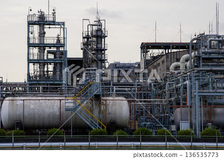 A huge distillation tower and complex piping in a chemical plant 136535773