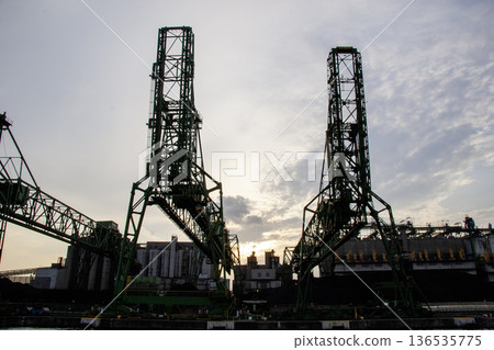 Gantry cranes lined up at the port and raw materials piled up 136535775