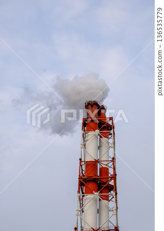 White smoke rising into the sky from a red and white chimney White smoke rising into the sky from a red and white chimney 136535779