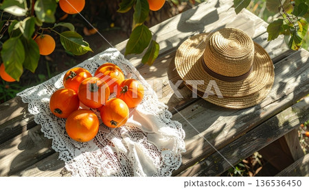 Persimmon with Straw Hat on Rustic Wooden Table 136536450