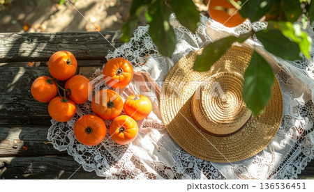 Persimmon with Straw Hat on Rustic Wooden Table 136536451