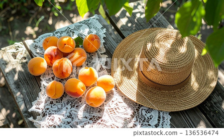 Apricots with Straw Hat on Rustic Wooden Table 136536474