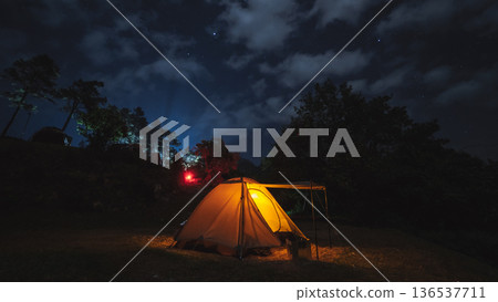 nature traveling with orange camping tent on mountain with milky way and star background nature traveling with orange camping tent on mountain with milky way and star background 136537711