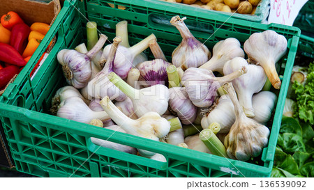 Fresh white garlic with stems in a large quantity in a green plastic case Fresh white garlic with stems in a large quantity in a green plastic case 136539092