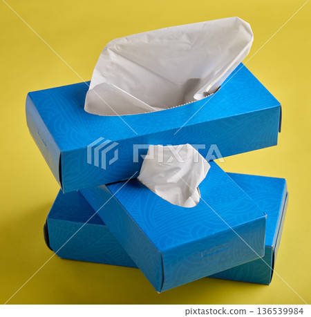 Stacked Blue Tissue Boxes on Bright Yellow Background Stacked Blue Tissue Boxes on Bright Yellow Background 136539984