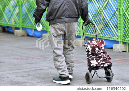 Yokohama cityscape in Japan. An elderly man wearing a mask on his arm in an aging society. Caught between the curses. = Yokohama city (Yokohama Station West Exit) 136540202