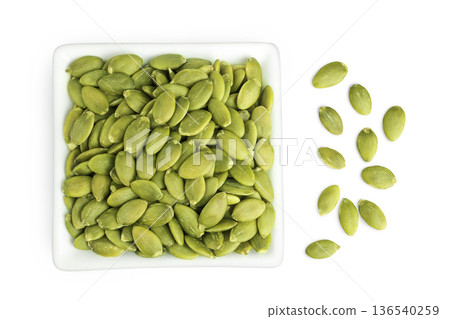 Peeled pumpkin seeds in ceramic bowl isolated on white background. Top view. Flat lay Peeled pumpkin seeds in ceramic bowl isolated on white background. Top view. Flat lay 136540259