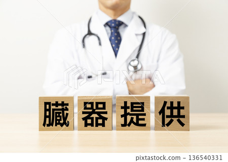 A block with the word "organ donation" written on it and a doctor 136540331