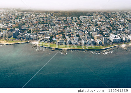 Sea point Promenade, Cape Town. Aerial view of coastal city from helicopter tour. Urban landscape with deep blue ocean and green strip. Luxury vacation travel destination. 136541289