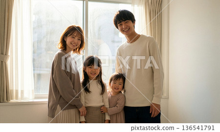 Smiling family in a room with a window 136541791