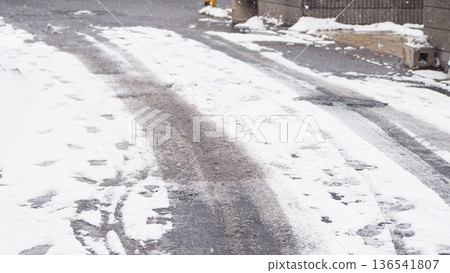 汽車駛過後,路面積雪覆蓋。 汽車駛過後,路面積雪覆蓋。 136541807
