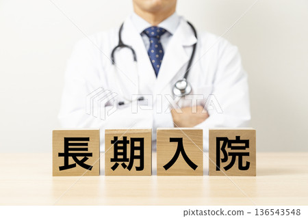 一塊寫著「長期住院」字樣的方塊和一個醫生 一塊寫著「長期住院」字樣的方塊和一個醫生 136543548