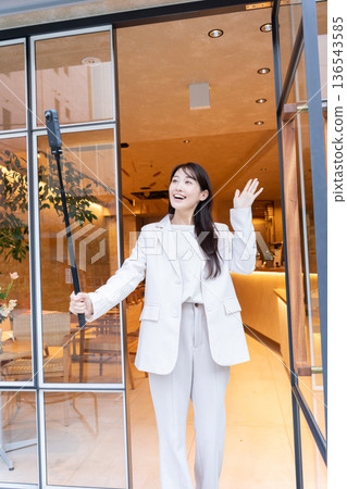 A young woman streaming video with a 360-degree camera at the entrance of a cafe A young woman streaming video with a 360-degree camera at the entrance of a cafe 136543585