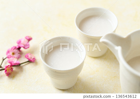 用麴菌釀造的甜酒倒入小杯中 用麴菌釀造的甜酒倒入小杯中 136543612