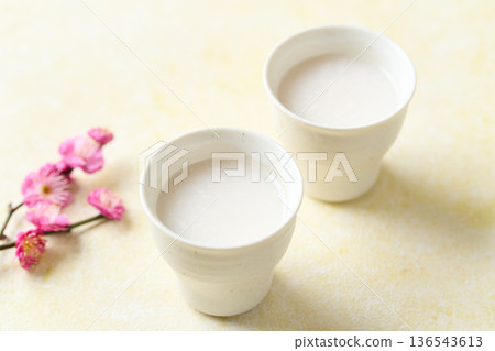 用麴菌釀造的甜酒倒入小杯中 用麴菌釀造的甜酒倒入小杯中 136543613