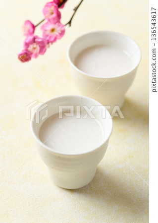 用麴菌釀造的甜酒倒入小杯中 用麴菌釀造的甜酒倒入小杯中 136543617