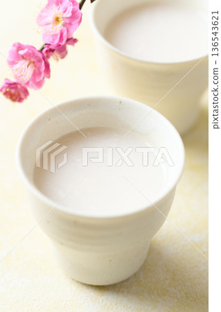 用麴菌釀造的甜酒倒入小杯中 用麴菌釀造的甜酒倒入小杯中 136543621