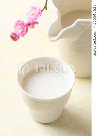 用麴菌釀造的甜酒倒入小杯中 用麴菌釀造的甜酒倒入小杯中 136543625