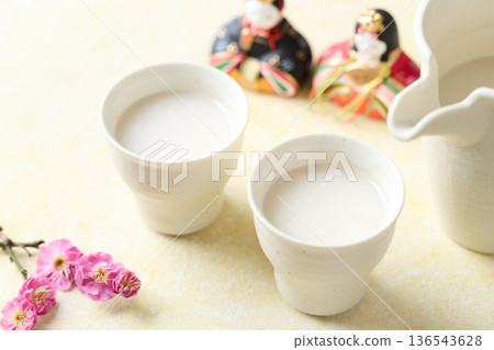 用麴菌釀造的甜酒倒入小杯中 用麴菌釀造的甜酒倒入小杯中 136543628