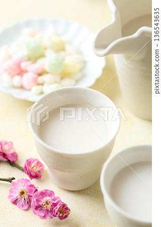 用麴菌釀造的甜酒倒入小杯中 用麴菌釀造的甜酒倒入小杯中 136543635