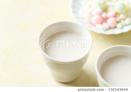 用麴菌釀造的甜酒倒入小杯中 用麴菌釀造的甜酒倒入小杯中 136543644