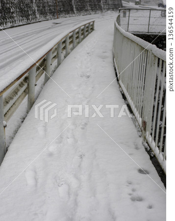 路邊的人行道上積滿了雪。 路邊的人行道上積滿了雪。 136544159