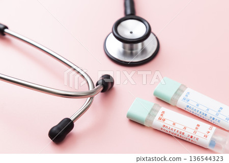 粉紅色背景上的糞便檢測試劑盒和聽診器 粉紅色背景上的糞便檢測試劑盒和聽診器 136544323