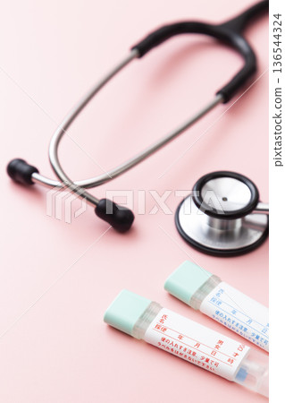 粉紅色背景上的糞便檢測試劑盒和聽診器 136544324