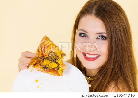 Woman eating hot pizza slice Woman eating hot pizza slice 136544710