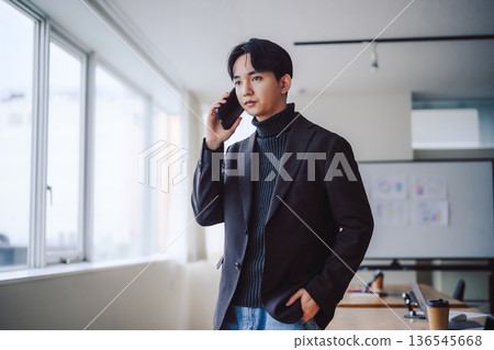 A businessman talking on a smartphone in the office 136545668