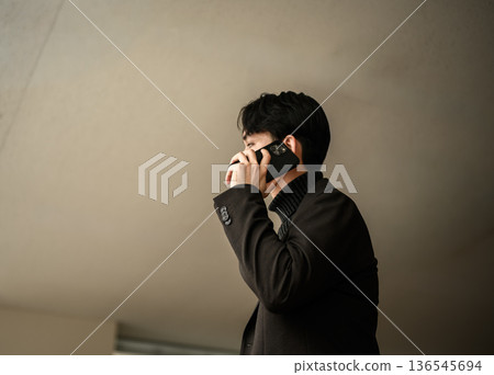 A young man talking on a smartphone A young man talking on a smartphone 136545694