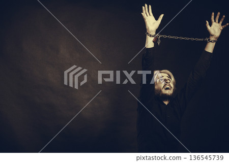 Furious man with chained hands, no freedom 136545739