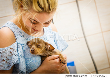 Woman playing with dog in bathroom Woman playing with dog in bathroom 136545879