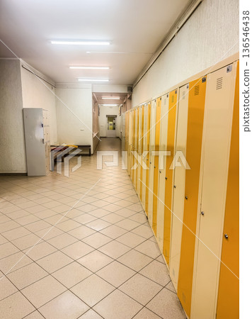 Leading lines and perspective in a deserted locker room. The alternating yellow and white doors create a vibrant, graphic pattern along the long, tiled corridor.High quality photo Leading lines and perspective in a deserted locker room. The alternating yellow and white doors create a vibrant, graphic pattern along the long, tiled corridor.High quality photo 136546438