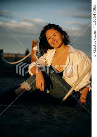 Woman Smiling at Sunset on the Beach 136547060
