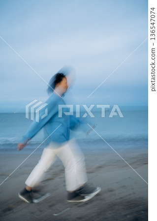 Motion Blur of Person Walking on Beach 136547074