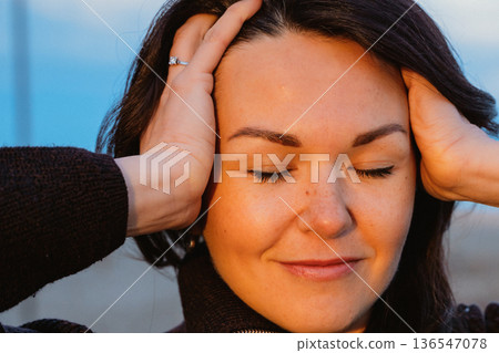 Woman Relaxing with Eyes Closed in Peaceful Moment 136547078