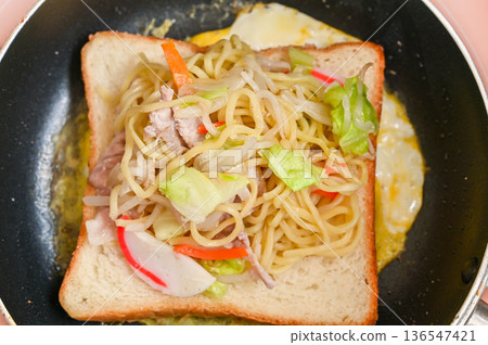 麵包和鹹炒麵放在蛋上。 136547421