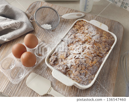 Sponge cake with petals, almond flakes, and powdered sugar. Dessert and home celebration. Cooking and hobbies. 136547460