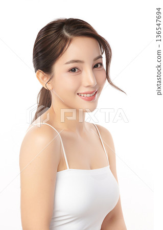 A beautiful young Asian woman with clean, fresh skin against a white background. Skincare, facial treatment, cosmetology, beauty, and spa. An elegant portrait of an Asian woman. 136547694