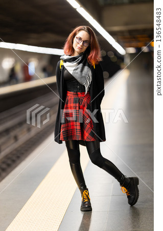 Young woman commuting, standing on urban subway platform Young woman commuting, standing on urban subway platform 136548483