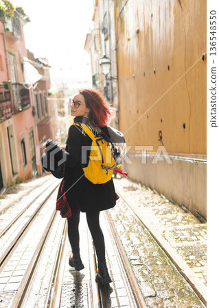 Young woman walking tram tracks exploring european city street 136548550