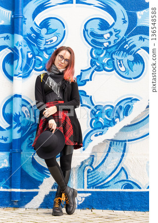 Young woman posing against blue street art wall Young woman posing against blue street art wall 136548588
