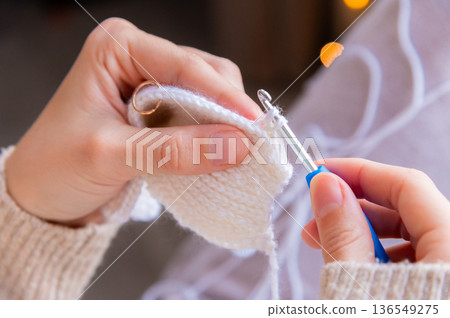Young happy woman crocheting at home relaxing and meditating 136549275